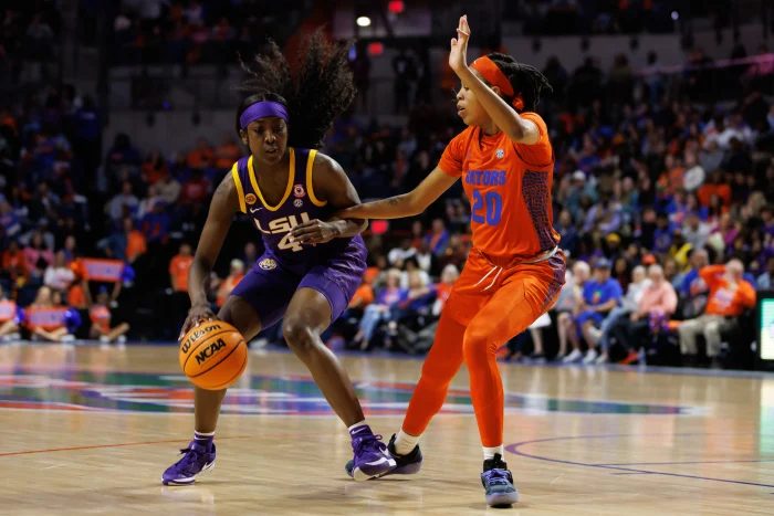 Jan 19, 2025; Gainesville, Florida, USA; LSU Tigers guard Flau'Jae Johnson (4) drives to the basket at Florida Gators guard Jeriah Warren (20) during the second half at Exactech Arena at the Stephen C. O'Connell Center